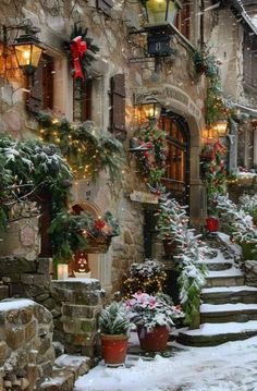 a stone building with christmas decorations on the windows and steps leading up to an entrance