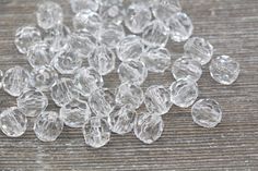 clear glass beads are scattered on a wooden surface