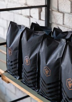 bags of coffee sitting on a shelf in front of a brick wall