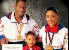 a man and woman holding a small child in front of an olympic medal plaque with the caption on it