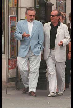 two men in suits walking down the street