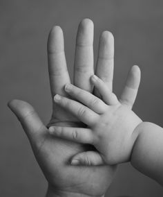 a black and white photo of a baby's hands