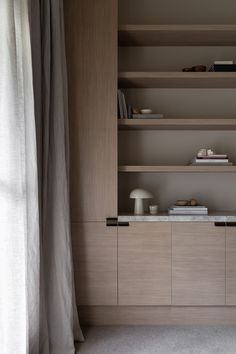 an empty room with shelves and curtains