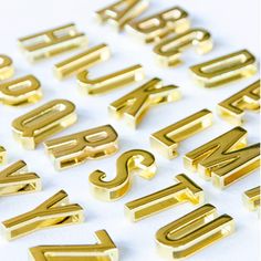 the letters are gold in color and have been placed next to each other on a white surface