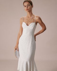 a woman wearing a white dress and holding a clutch