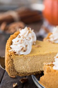 a slice of pumpkin pie with whipped cream on top and pecans in the background