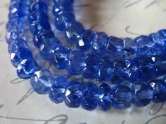 three strands of blue glass beads on top of a piece of paper