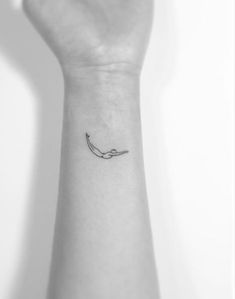 a person's arm with a small tattoo on the left side of their wrist