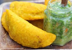 some food that is sitting on a wooden board next to a jar with something in it