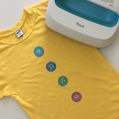 a yellow shirt with buttons on it next to a machine