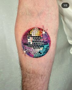 a colorful disco ball tattoo on the leg