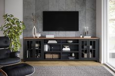 a living room with a large television on the wall and a black chair in front of it