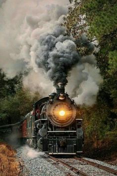 an old fashioned steam train is traveling down the tracks