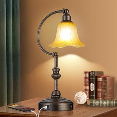 a lamp on a desk next to some books