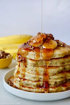 a stack of pancakes with syrup and bananas