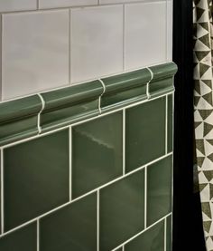 green and white tiled wall next to shower curtain