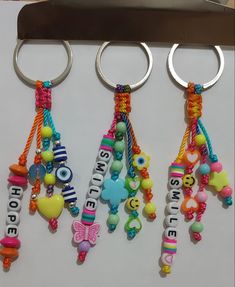 three key chains with name charms attached to them