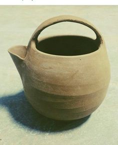 a clay pot sitting on top of a cement floor