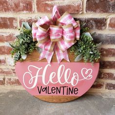 a wooden sign that says hello valentine hanging on a brick wall