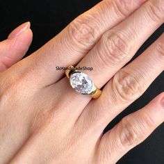 a woman's hand with a yellow and white diamond ring on top of it