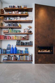 a room with a fireplace and shelves filled with books