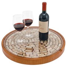 two glasses of wine sitting on top of a cork coaster