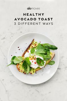 a white plate topped with an egg and spinach on top of toasted bread