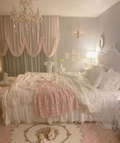 a white bed sitting in a bedroom next to a chandelier