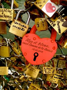 a bunch of padlocks that are attached to a fence with love locks on them