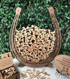 a wooden basket filled with lots of cut out pieces of wood next to some green leaves