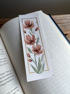 an open book with watercolor flowers on it