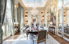 an elegant dining room with chandelier and large glass doors leading to another room