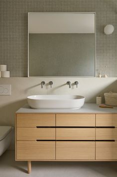 a bathroom with two sinks and a large mirror over the sink, in front of a white toilet