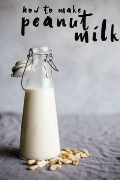 a glass bottle filled with milk and almonds on top of a bed next to the words how to make peanut milk