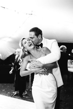 a man and woman are dancing together on the dance floor at a wedding reception in black and white