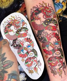 two people with tattoos on their arms and one has a skateboard in front of them