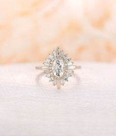 a white gold ring with an oval cut diamond surrounded by smaller round diamonds on top