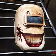 a creepy looking mask with blood on it's face and mouth is attached to a metal rack