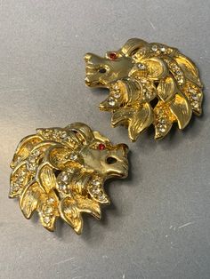 BEAUTIFUL VINTAGE CRAFT LIONS HEADS DESIGNER RED CRYSTAL EYES SPARKLING ORNATE GOLD METAL SAFARI STATEMENT RUNWAY SIGNED CLIP ON EARRINGS !! A GORGEOUS pair of vintage signed clip on earrings by the designer "Craft". Featuring beautiful lions heads with manes covered in sparkling crystals. Red crystals as the eyes. Full of elegance!! A real statement pair of earrings! All done in a rich ornate high quality gold plated metal. The detail is WOW! So incredibly eyecatching. The perfect pair of earri Gucci Earrings Lion, Luxury Gold Ornate Clip-on Earrings, Luxury Ornate Yellow Gold Earrings, Crystals Red, Beautiful Lion, Crystal Eyes, Crystal Eye, Vintage Crafts, Lion Head