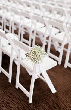 white folding chairs with baby's breath flowers on them are set up for an outdoor ceremony