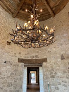 a chandelier hanging from the ceiling in a stone building