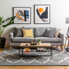 a living room with two paintings on the wall and a coffee table in front of it