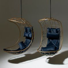 two hanging chairs with blue cushions in the shape of an moon and crescent shaped chair