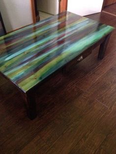 a wooden table sitting on top of a hard wood floor next to a mirror in a room