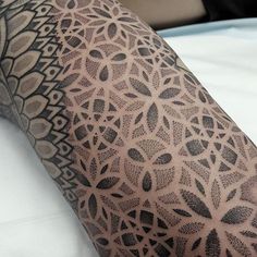 a close up of a person's arm with tattoos on it and an intricate design