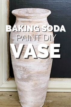 a white vase sitting in front of a black door with the words baking soda painted on it