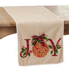 an embroidered table runner with the word joy on it