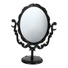 an ornate black vanity mirror sitting on top of a metal stand with a white background