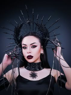 Gorgeous black gothic crown with spikes made of zip ties coated with liquid plastic. The crown is decorated with natural feathers coated with liquid plastic, the center of the crown is decorated with a sun icon, as well as rhinestones and glass rhinestones on a metal ribbon. Ideal for special occasions and fine costumes, as well as holidays, festivals and celebrations. The crown will be an excellent prop for artistic photography.  The size of this headgear is universal for an adult. It sits soft Sunburst Crown, Crown Dark, Gothic Crown, Festival Headpiece, Feather Coat, Goddess Crown, Avant Garde Hair, Goddess Of Victory, Dark Queen