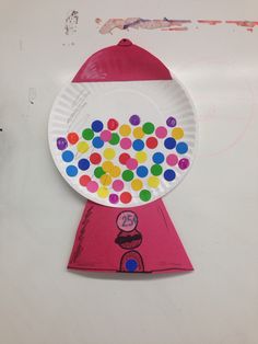 a paper plate shaped like a gumball machine with lots of colorful dots on it